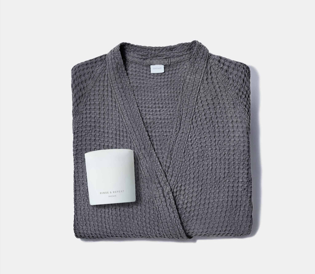 one grey folded honeycomb bathrobe and a white scented candle