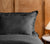 Noir-colored pillow cover and a lamp and table in the bed side