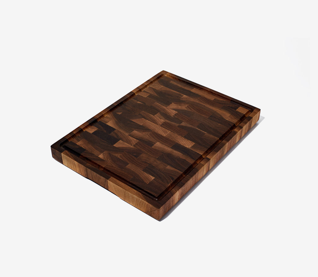 End-Grain hand crafted, black walnut, rectangular cutting board with a white background.