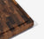 Close up of the juice grooves of our End-Grain hand crafted, black walnut, rectangular cutting board with a white background.