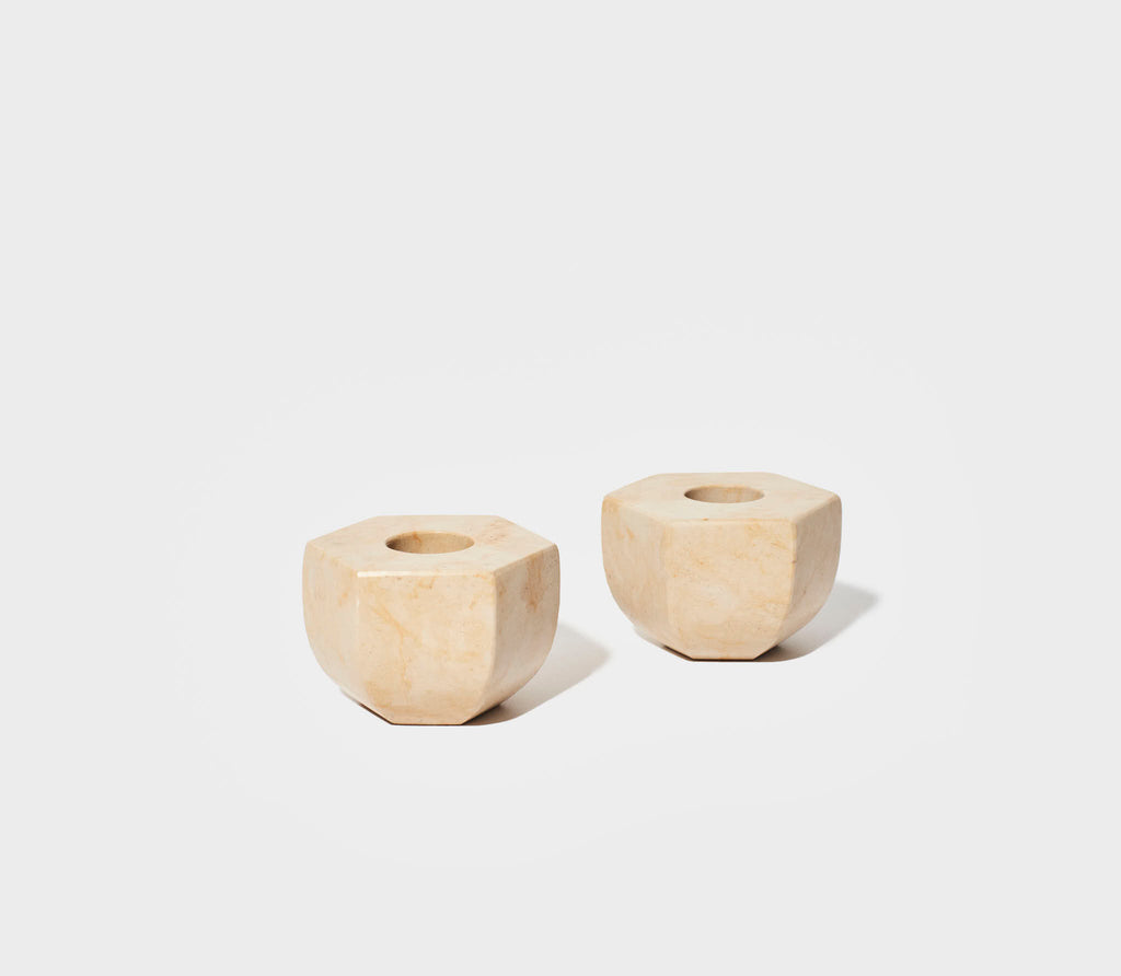 a pair of two sand colored marble candle holders