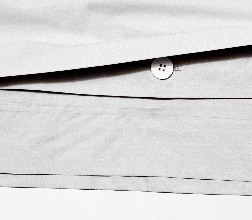 close up grey duvet cover with a round button