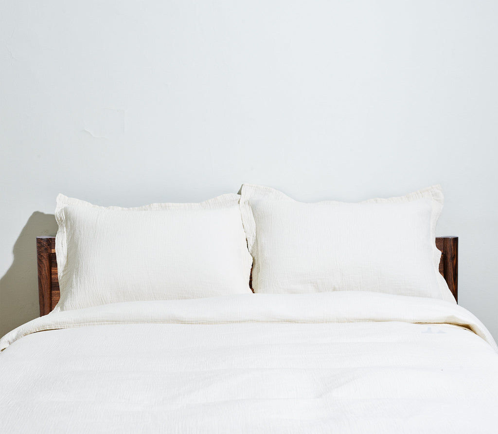 ivory colored two pillows and one duvet cover